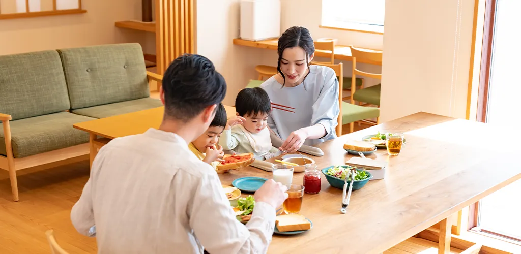 木の温もりあふれるリビングで食事をする家族